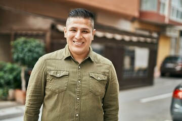 Fototapeta premium Young latin man smiling happy standing at the city.