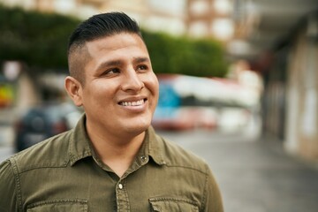 Young latin man smiling happy standing at the city.