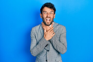 Handsome man with beard wearing business suit and tie shouting and suffocate because painful strangle. health problem. asphyxiate and suicide concept.