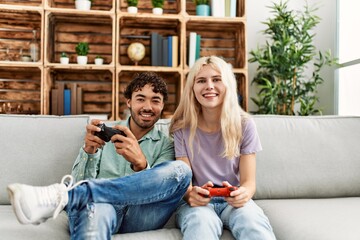 Fototapeta premium Young couple smiling happy playing video game at home.
