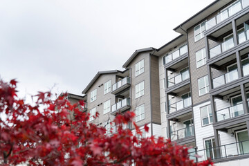Low angle view of a complex building with a blurry red leaves at the front - Powered by Adobe