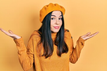 Young brunette woman wearing french look with beret clueless and confused with open arms, no idea and doubtful face.