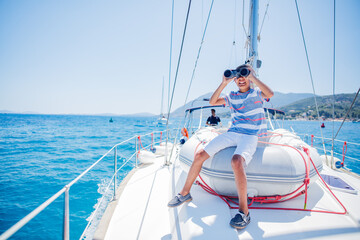 Little boy on board of sailing yacht on summer cruise. Travel adventure, yachting with child on...