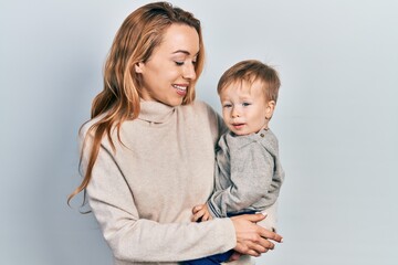 Young caucasian woman holding and hugging her son with love. Family of two bonding together. Mother holding infant toddler