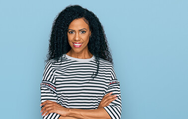 Middle age african american woman wearing casual clothes happy face smiling with crossed arms looking at the camera. positive person.