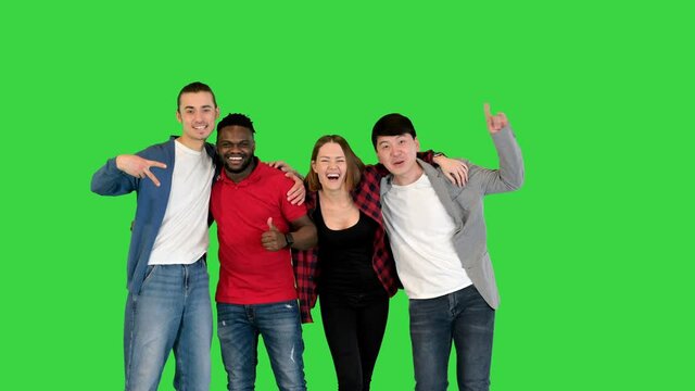 Group of young people smiling and laughing in front of camera, thumbs up on a Green Screen, Chroma Key.