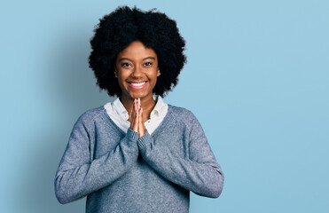 Young african american woman wearing business clothes praying with hands together asking for...