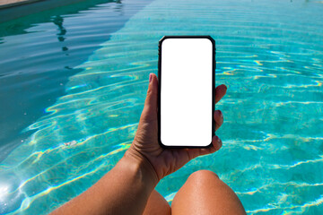 woman on vacation by the pool with mobile phone in hand