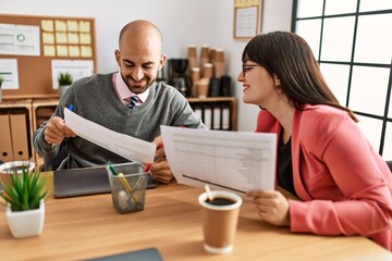 Two hispanic business workers smiling happy working at the office.