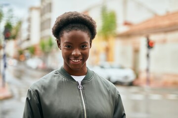 Young african american girl smiling happy standing at the city.