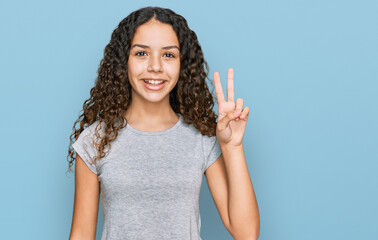 Teenager hispanic girl wearing casual clothes smiling with happy face winking at the camera doing...