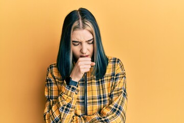 Young modern girl wearing casual yellow shirt feeling unwell and coughing as symptom for cold or...