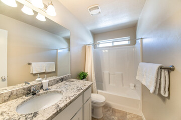 Small plain white bathroom with vanity and bathtub