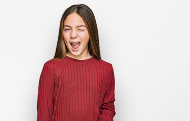 Obraz premium Beautiful brunette little girl wearing casual sweater winking looking at the camera with sexy expression, cheerful and happy face.