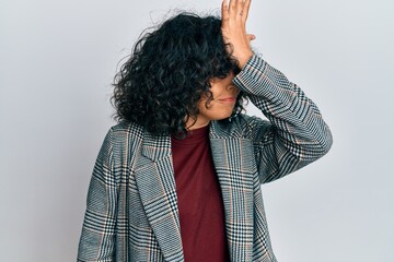 Young hispanic woman wearing business clothes surprised with hand on head for mistake, remember...
