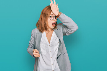 Young caucasian woman wearing business style and glasses surprised with hand on head for mistake,...