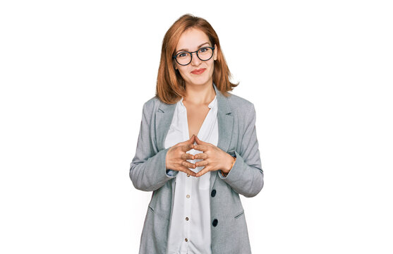 Young caucasian woman wearing business style and glasses hands together and fingers crossed smiling relaxed and cheerful. success and optimistic