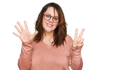 Young plus size woman wearing casual clothes and glasses showing and pointing up with fingers number seven while smiling confident and happy.