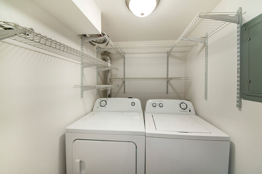 White Laundry Room With Shelves With Adjustable Brackets.