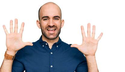 Young hispanic man wearing casual clothes showing and pointing up with fingers number ten while smiling confident and happy.