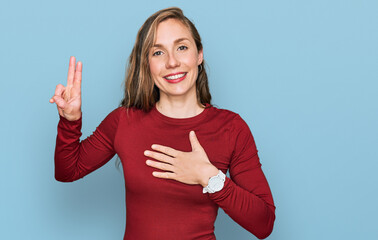 Young blonde woman wearing casual clothes smiling swearing with hand on chest and fingers up,...