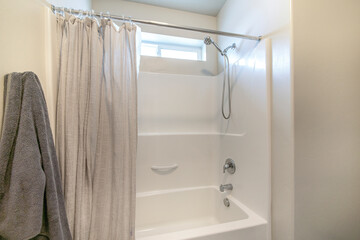 Bathroom interior with tub shower combo and window