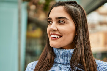 Fototapeta premium Young hispanic girl smiling happy standing at the city
