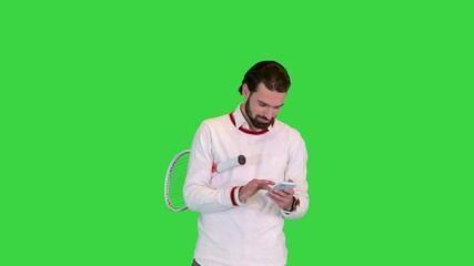 Handsome male tennis player using smartphone on a Green Screen, Chroma Key. - Powered by Adobe