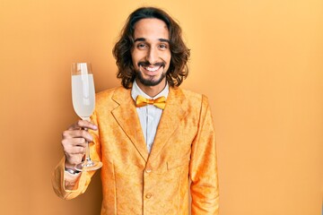 Young hispanic man wearing nerd elegant style drinking a glass of sparkling champagne looking...