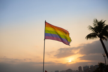 Gay pride flag fluttering during sunset in Santos