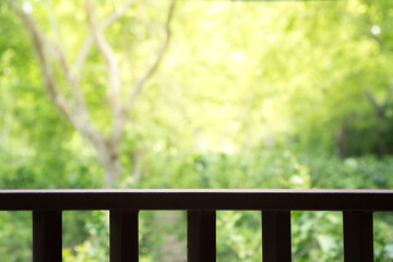 Fototapeta premium Wooden slatted balcony on natural blurred background with sunlight