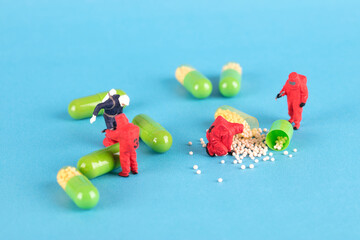 Resident Evil miniature figures checking medicines on blue background