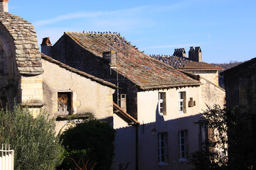 Fototapeta na wymiar A flock of pigeons on the roof of a stone house in Southern France
