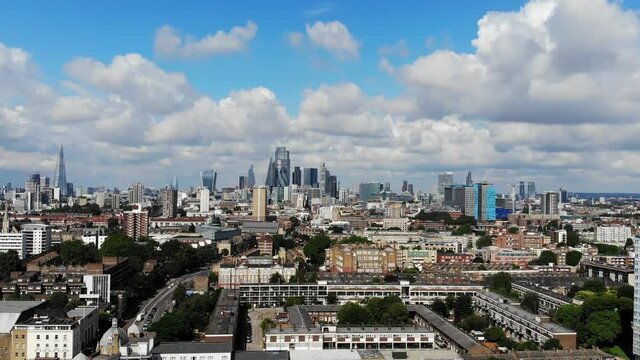 Aerial shot of London skyline against white puffy clouds on a sunny summer day