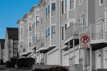 A row of white and gray homes with evening shadows.