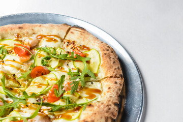 Pizza with rucola and cherry tomatoes over white
