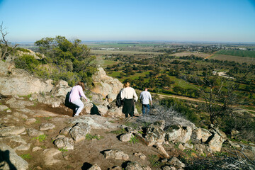 People climbing down Pyramid Hill with view of farmland and the town in the distance