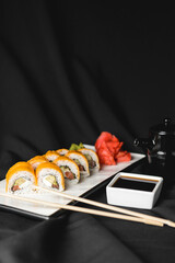 Sushi Rolls with processed cheese cheddar, american cheese, avocado, tuna and cream cheese inside on white slate