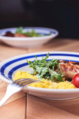 Risotto with pork sausages with cherry tomatoes and parsley on a plate. Italian cuisine concept