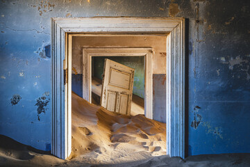 Abandoned building being taken over by encroaching sand in the ghost town of Kolmanskop near Luderitz, Namib Desert, Namibia.
