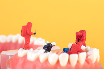 A miniature inspector model is examining the teeth of the oral cavity