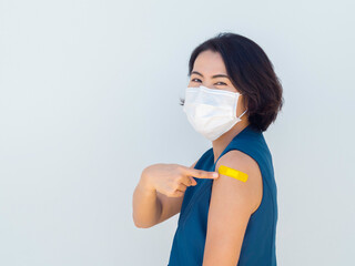 Vaccinations, bandage plaster on vaccinated people's arm concept. Yellow color adhesive bandage on...
