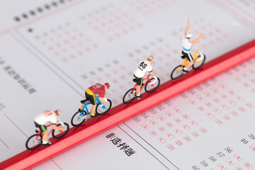 The pencil on the answer sheet is a group of miniature doll models riding bicycles to the finish line