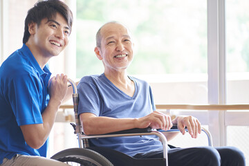 車椅子に乗る高齢者と介護士