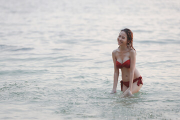 happiness on holiday of young asian beautiful and sexy girl in red bikini having happy time on beach in sunset on summer vacation