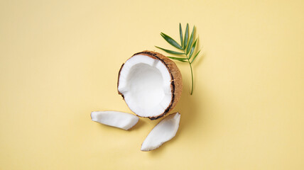 Eco friendly flat lay. Fresh coconut and slices  on yellow  background. Healthy and vegan food. Top...