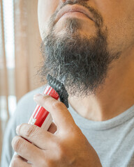 Shaving beard with electric razor machine.