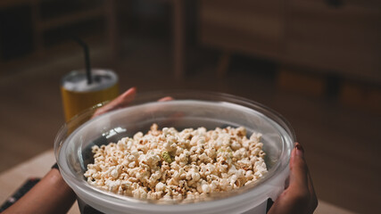 Cropped shot of man holding a bowl of popcorn.