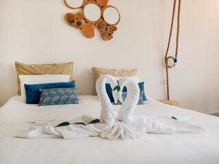 Towel white swans couple kiss heart shape on bed sheet hotel guest room decoration background 