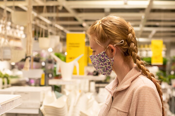 A girl wearing face mask in department store during COVID-19 pandemic.